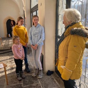 Elisabeth begrüßt die Sternsinger und sucht dann mit ihnen Kleider aus © M. Löffelberger