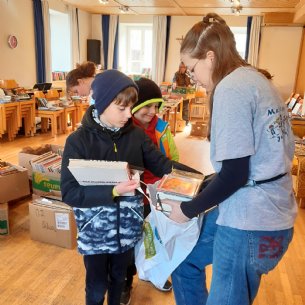 Tüchtige Verkäuferin und begeisterte Käufer beim Bücherflohmarkt &copy; M. Löffelberger