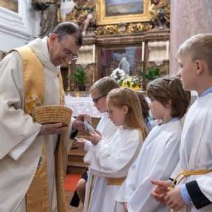 Den Kindern wird ein Kreuz als Andenken zur Erstkommunion geschenkt &copy; Chris Hofer